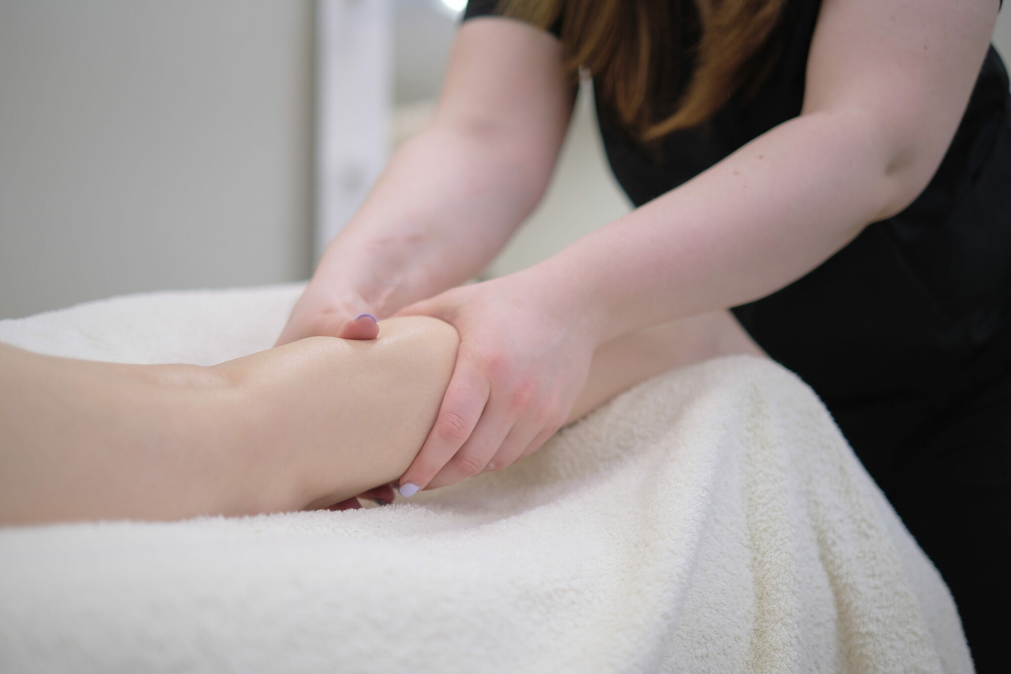A woman receiving a massage at an osteopath clinic.