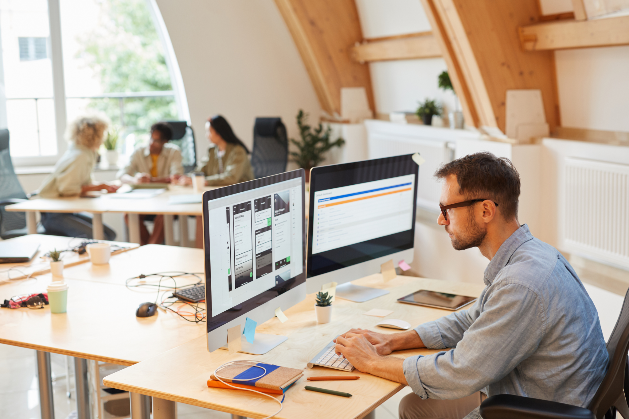 A group of people working at a desk in an office.