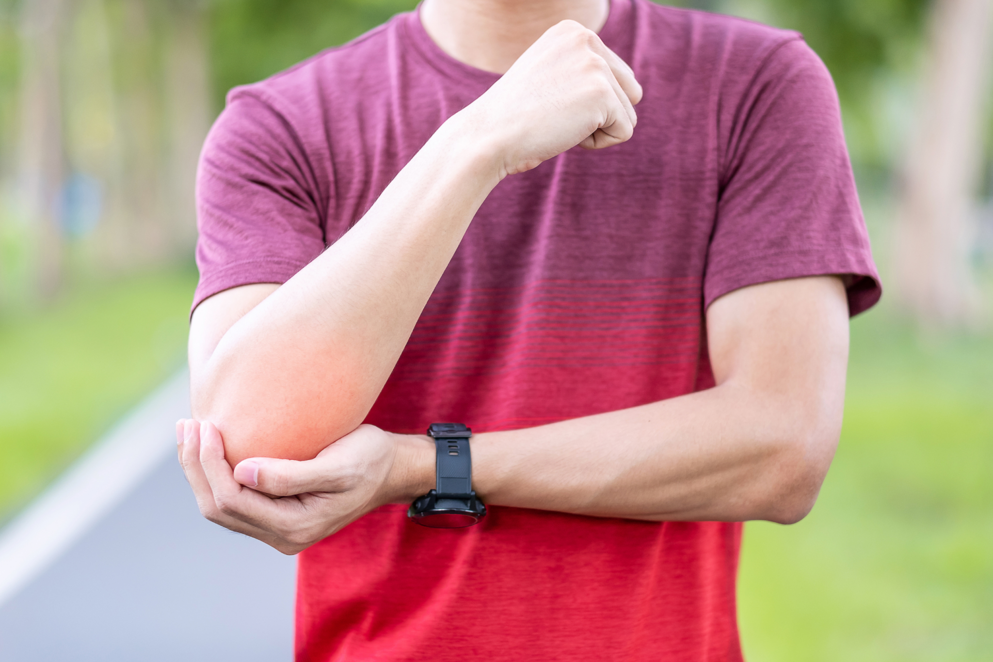 A man with a wrist injury in a park.